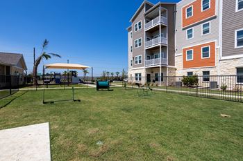 Large fenced in dog park with agility equipment at Promenade Luxury Apartments in Beaumont, Texas